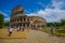 ROME, ITALY - JUNE 13, 2015: Roman coliseum view from outside, turists walking and visiting this iconic structure