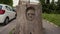 Rome, Italy - May 14, 2019: Mans face carved into old tree stump. Hand-made landmark. Rome, Italy