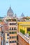 Rome skyline with old colorful houses and rooftop terraces on sunny day. Dome of San Carlo al Corso basilica on the