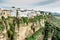 Ronda. Landscape of white houses on the edge of steep cliffs Tajo Gorge with mountains in the background. Village panorama