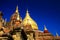 Roof of ancient brick stone temple with golden dome contrasting with deep blue sky -  Bagan, Myanmar