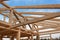 Roof beams. Sunny autumnal evening at the construction site of a wooden house. Unfinished house.