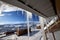 Roof with big sunlit icicles and small wooden houses at snowy winter mountains