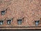 Roof of a building from the early Middle Ages with ancient bricks and some dormer windows