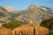 The roof of the Bungalow on the beach is thatched background of mountains and pine trees against the blue sky