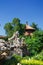 Roof of Chinese pagoda in lush green garden with rockery and tree