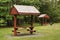 Roof covered picnic tables in park setting.