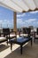 Roof in front of the sea with tanned beds, armchais, blue sky and white clouds