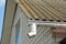 A roof gutter installation mistake. A close-up of a rain gutter attached to an asbestos roof without a downspout, downpipe