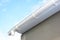 Roof gutter repair. Rain gutter installation with drain downspout pipe. Guttering with soffits