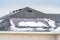 Roof of a home with solar panels against a vast cloudy blue sky