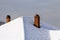 Roof of the house with brick chimneys covered with snow in winter