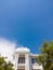 The roof of the house with nice window under the blue sky and bright green trees. Sale and rental of real estate concept