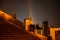 Roof of houses with chimneys and a church tower in night, Uherske Hradiste