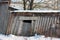 The roof of an old abandoned house in the village in winter. Snowy and Sunny day. Empty house, without people, dilapidated, broken