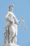 Roof statue of the Lady Justice, goddess of Justice, with scales and sword at blue smooth sky in Potsdam, Germany