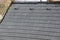 Roof tiles made of plastic imitation wooden shingles. view of rows of gray narrow recycled boards. vents in several elegant bumps.