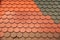 Roof tiles of the same shape but differing in color and surface