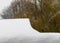 Roof of the underpass in the snow against the background of an autumn tree with yellow leaves covered with the first snow. Autumn