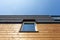 Roof Window on new wooden house against blue sky.