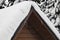 Roof of wooden house is covered with snow. Sudden snowfall poured frost and ice