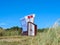 Roofed wicker beach chair Norderney in dunes blue sky