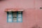 Roofed window with closed wooden shutter - colorful building ext