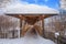 Roofed wooden bridge with big snow cap