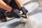 Roofer builder worker finishing folding a metal sheet using special pliers with a large flat grip.