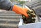 Roofer cleaning with hand roof gutter from fallen leaves and dirt in fall