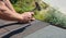 Roofer with hammer in motion, laying asphalt shingles tiles on house roof. Roofing Construction panorama photo