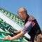 Roofer hammering nails into beams