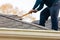 Roofer removing roof nails with roof shingle remover
