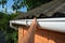 Roofer repair and renovate roof gutter on old brick house asbestos roof