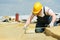 Roofer worker measuring insulation material