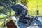 Roofer worker using battery-powered gun