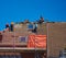 Roofers renovating with a bright blue sky sloping roof