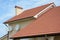 Roofing Construction. House with red clay tiled roof and gable and valley type of roof construction.