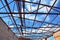 Roofing construction. Steel roof trusses details with clouds sky background.