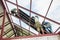 Roofing construction workers install metal sheet on the roof.