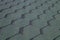 Roofing made of green soft bitumen tiles on a hipped roof of a house. Close up view of Asphalt Roofing green Tile Background.
