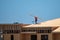 Roofing on roof. Builder roofer install new roof. Construction worker roofing on a large roof apartment building