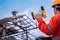 Roofing tools, Roofer worker holding electric drill used on new roofs with Metal Sheet at construction site