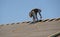 A roofing worker with tape measure