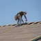 A roofing worker with tape measure