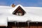 A rooflight with a lot of snow and icicles from an old farmhouse in bavaria