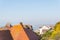 Roofs of buildings in a seaside village, ocean view, sunny day