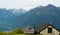 Roofs of houses on a background of beautiful and big mountains in the alpine mountains of Switzerland.