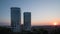 The roofs of tall concrete skyscraper towers in the central business district of a modern city descend to street and