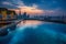 Rooftop infinity pool with panoramic city views at late sunset time, exuding a lavish and exclusive atmosphere